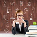 Composite image of redhead teacher sitting at desk