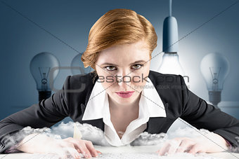 Composite image of redhead businesswoman sitting at desk typing