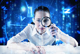 Composite image of businesswoman typing and looking through magnifying glass