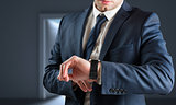 Composite image of businessman checking the time on watch