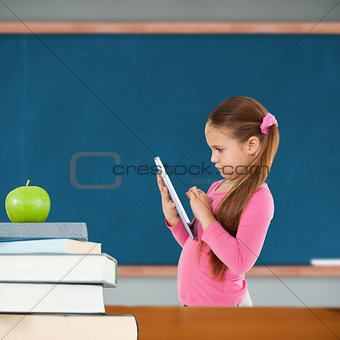 Composite image of cute girl using tablet
