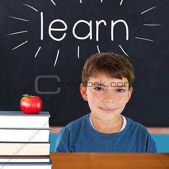 Learn against red apple on pile of books in classroom