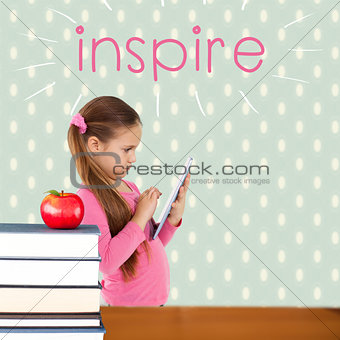 Inspire against red apple on pile of books