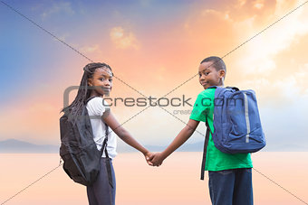 Composite image of cute pupils holding hands