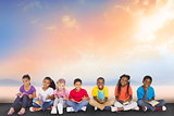 Composite image of cute pupils smiling at camera with books