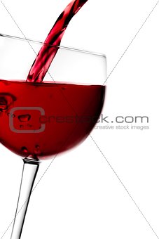 red wine pouring into half glass tilted with space for text 