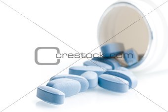 blue medical pills in laboratory near white container