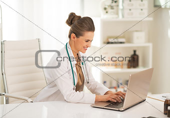 Doctor woman working on laptop in office