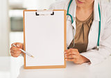 Closeup on doctor woman pointing on clipboard