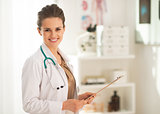 Portrait of doctor woman with clipboard in office