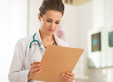 Doctor woman looking in clipboard
