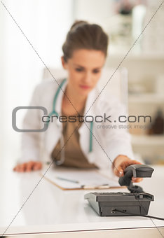 Closeup on doctor woman answering phone call