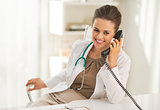 Happy doctor woman talking phone