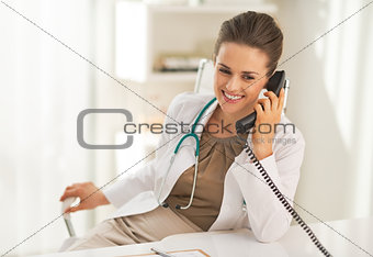 Happy doctor woman talking phone