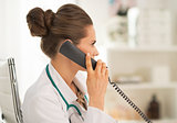 Doctor woman talking phone in office
