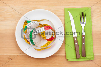 Plate with measure tape, knife and fork. Diet food