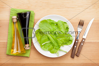 Plate with fresh salad, condiments, knife and fork. Diet food