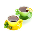 Two colorful cups of tea with lemon and mint