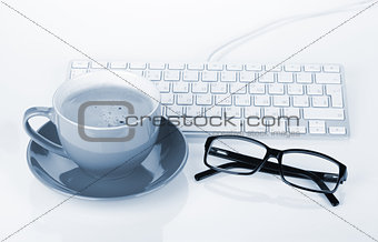 Coffee cup, glasses and computer keyboard