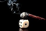 one white dice and cigar with smoke on black background