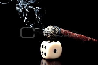 one white dice and cigar with smoke on black background