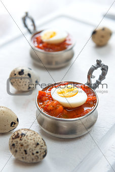 Hard boiled quail eggs with tomato sauce
