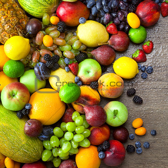 Mix of  Organic Fruits  with water drops on dark wooden table
