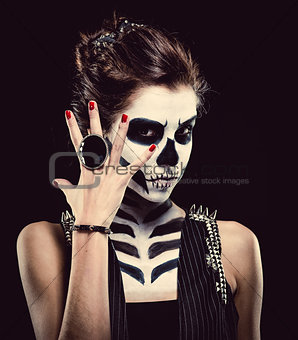 Woman with skeleton face art over black background