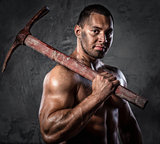 Muscular man holding pickaxe
