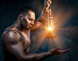 Muscular man holding oil lamp