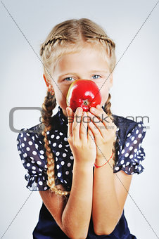 Smiling cute school girl playing with apples