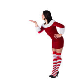 Pretty brunette in santa outfit blowing over hand