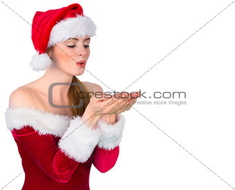 Pretty redhead in santa outfit blowing over hands