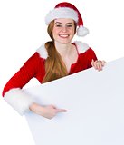 Pretty girl in santa costume showing card