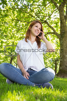 Pretty redhead on the phone in the park