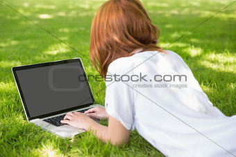 Redhead using laptop in the park