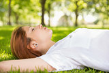Pretty redhead lying on grass relaxing