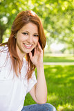 Pretty redhead smiling at camera in the park