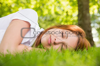 Pretty redhead lying on the grass