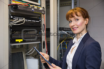 Pretty technician using tablet pc while fixing server
