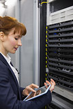 Pretty technician using tablet pc while working on servers