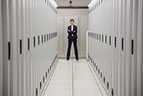 Serious technician standing in server hallway
