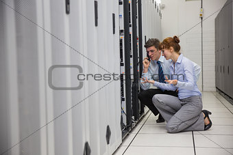 Team of technicians kneeling and looking at servers