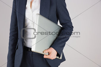 Businesswoman in suit holding laptop