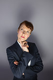 Businesswoman in suit thinking with finger on chin