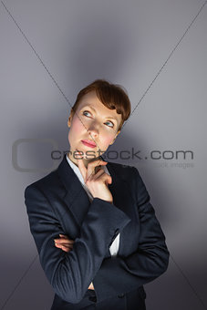 Businesswoman in suit thinking with finger on chin