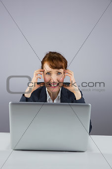 Stressed businesswoman working on laptop