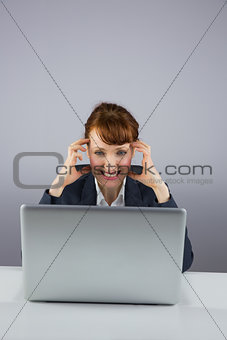 Stressed businesswoman working on laptop