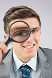 Businessman looking through magnifying glass