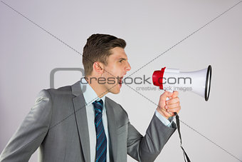 Angry businessman shouting through megaphone